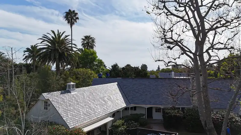 DaVinci composite slate-look roof on a white board-and-batten house among palms and trees