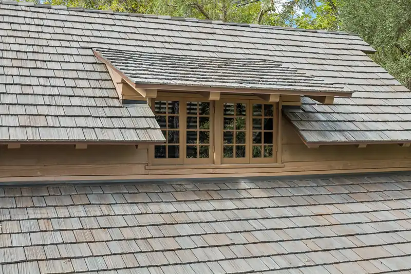 Brava composite shake tile on a wood-sided house with a shed dormer