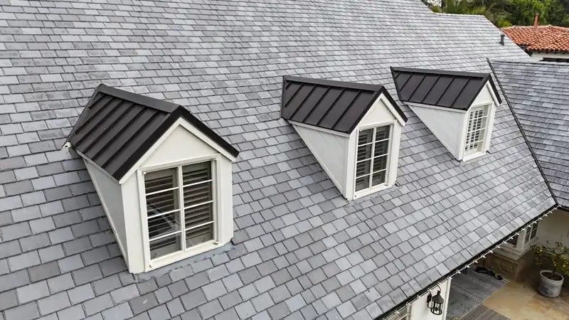 DaVinci composite slate-look roof in blended grays, with three dark metal-roofed dormers