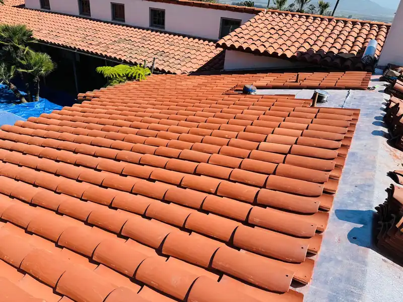 New clay barrel tile laid in neat courses over fresh underlayment on a Spanish style house