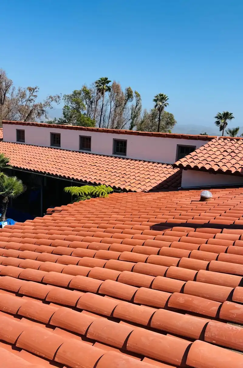 Clay barrel tile laid course by course across a long single-story roof